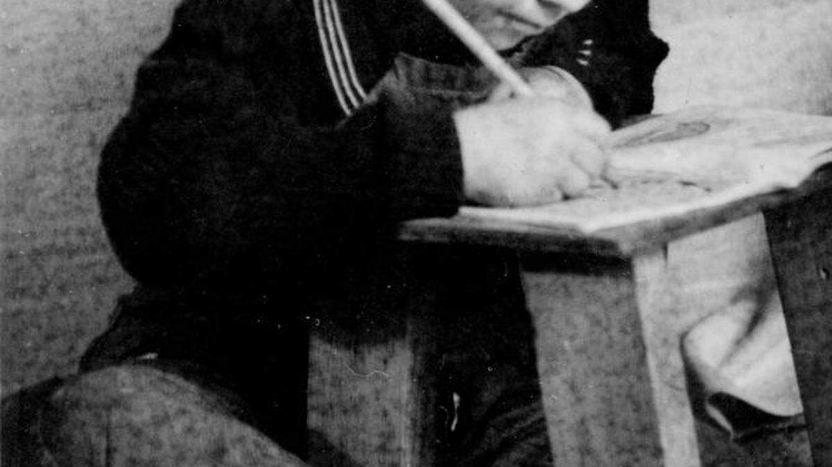 Andrew Hrebeniuk holds a pencil for the first time in a refugee holding area after being rescued from a Parshen, Germany, Nazi labor camp at the end of WWII.