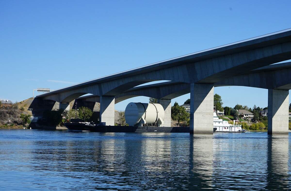 The defueled reactor compartment of USS City of Corpus Christi, a retired nuclear-powered submarine, floats under the Columbia River Interstate 182 bridge on its way to the Hanford nuclear site.