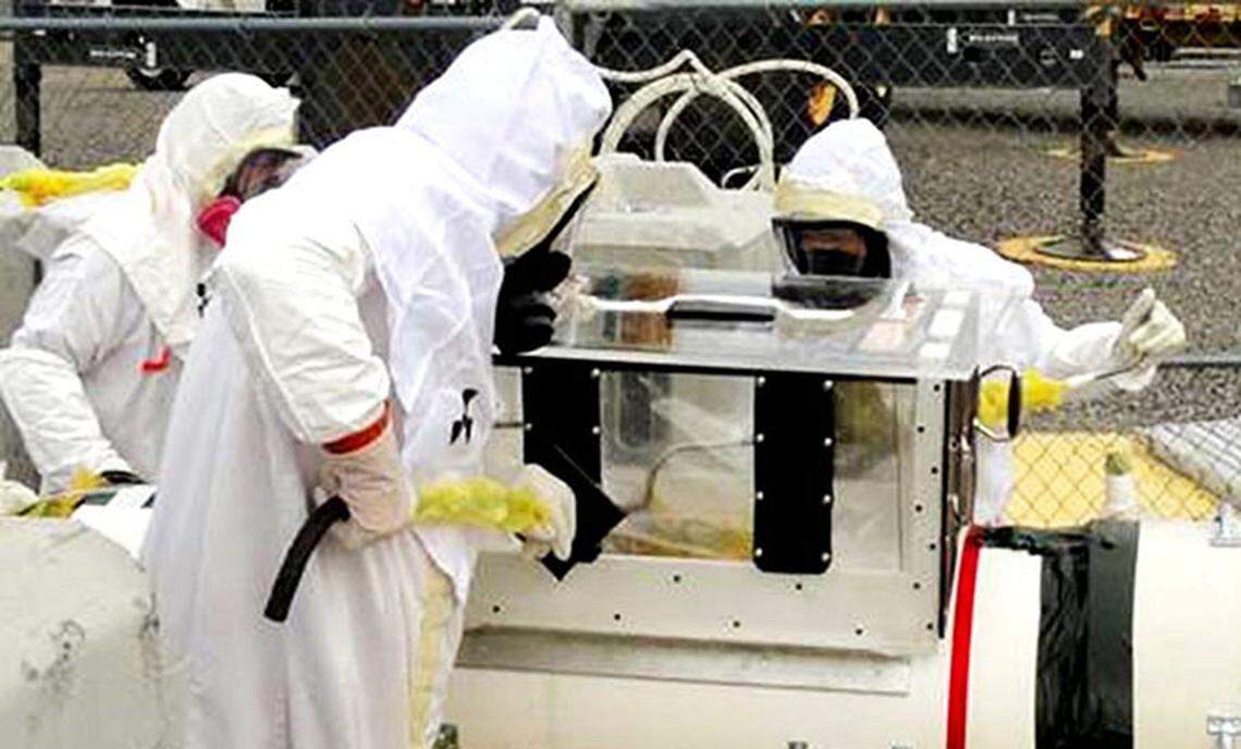 Hanford tank farm workers are shown in air-purifying respirators.