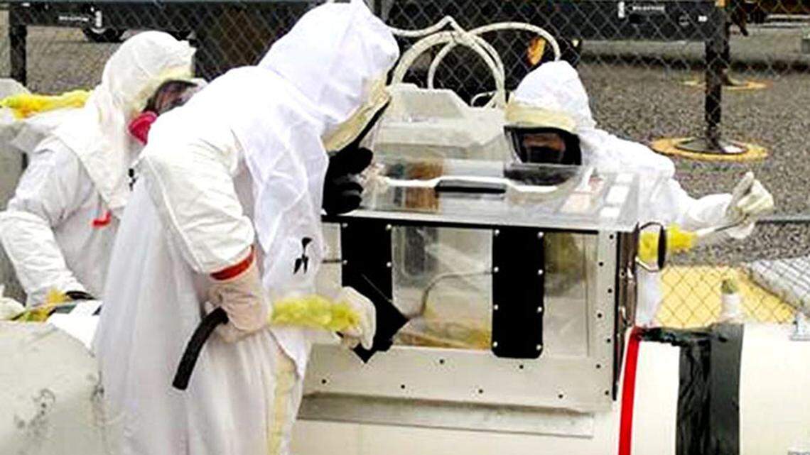 Tank farm workers at Hanford are shown in air-purifying respirators.