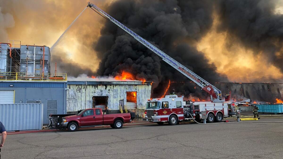 A Kennewick fire ladder truck works on dousing the fire at the Lineage Logistics warehouse in Finley.