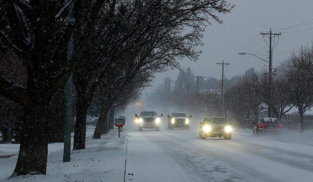 Snowfall early Tuesday reduces visibility for commuters navigating West 10th Avenue near South Union Street in Kennewick.