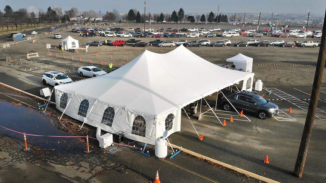 A cars pulls from the registration area towards a vaccination tent morning at the mass drive-thru COVID-19 vaccination site at the Benton County Fairgrounds in Kennewick.