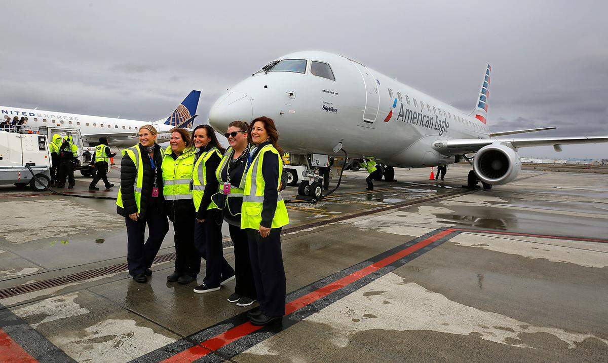 Local ground crew employees poses for a photo Thursday in front of the inaugural American Airlines flight to Pasco.