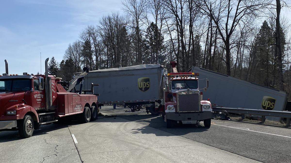 A tow truck worked at noon Thursday to remove UPS trailers after a crash early in the morning on Interstate 90 that killed two adults and a child from Yakima.