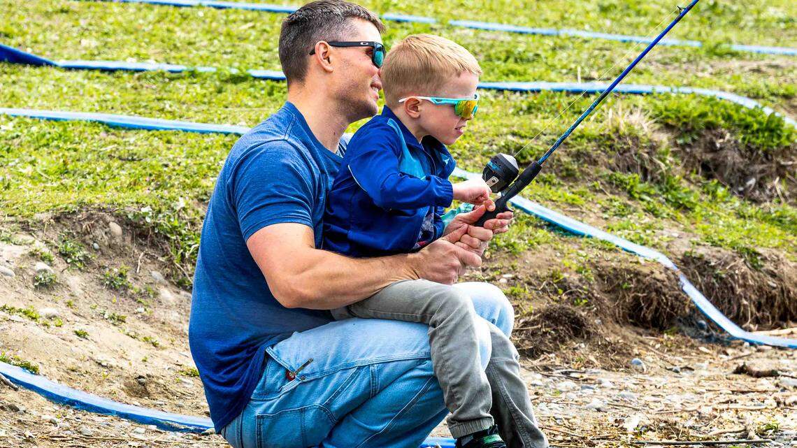 Dylan Hamm and his son Calvin, 5, of Pasco fish together during Kids Fishing Day at Columbia Park Pond in Kennewick. It was Calvin’s first-time fishing.