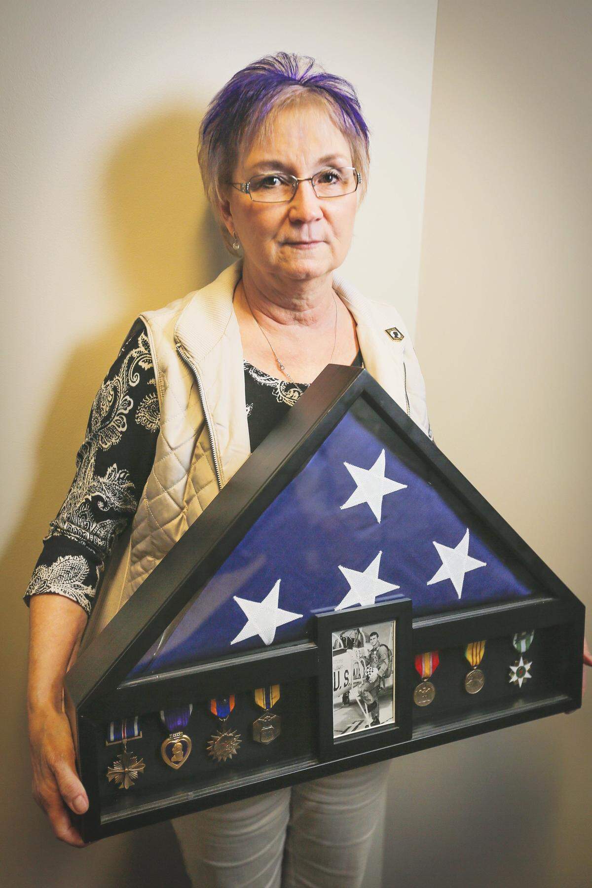 Terri Francisco-Farrell holds a shadow box with a photo of her brother, San D. Francisco, his medals and U.S. flag. Francisco was in the Air Force and been missing since he was shot down in the former North Vietnam on Nov 25, 1968.