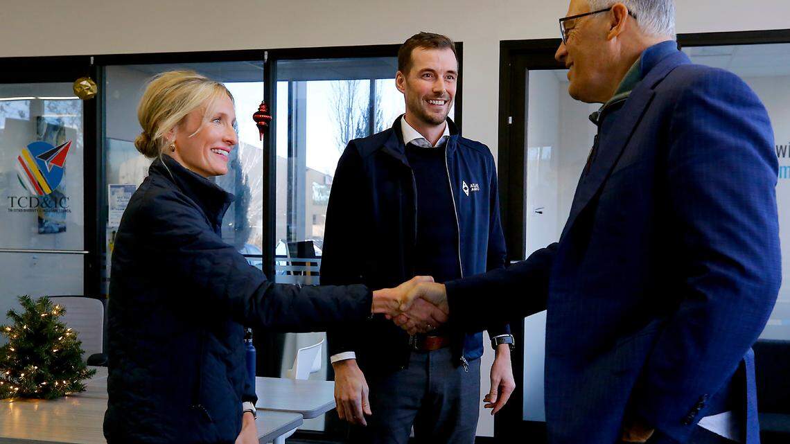 Gina Zejdlik, Atlas Agro director of policy and government relations, left and Dan Holmes, Atlas Agro North America executive director, middle, greet Gov. Jay Inslee Friday at a shared office space building in Richland.