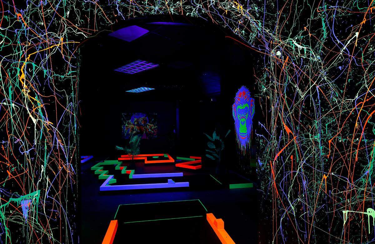 Black lights and neon paint create a colorful glow inside the dark Let’s Glow Mini Golf in Kennewick.