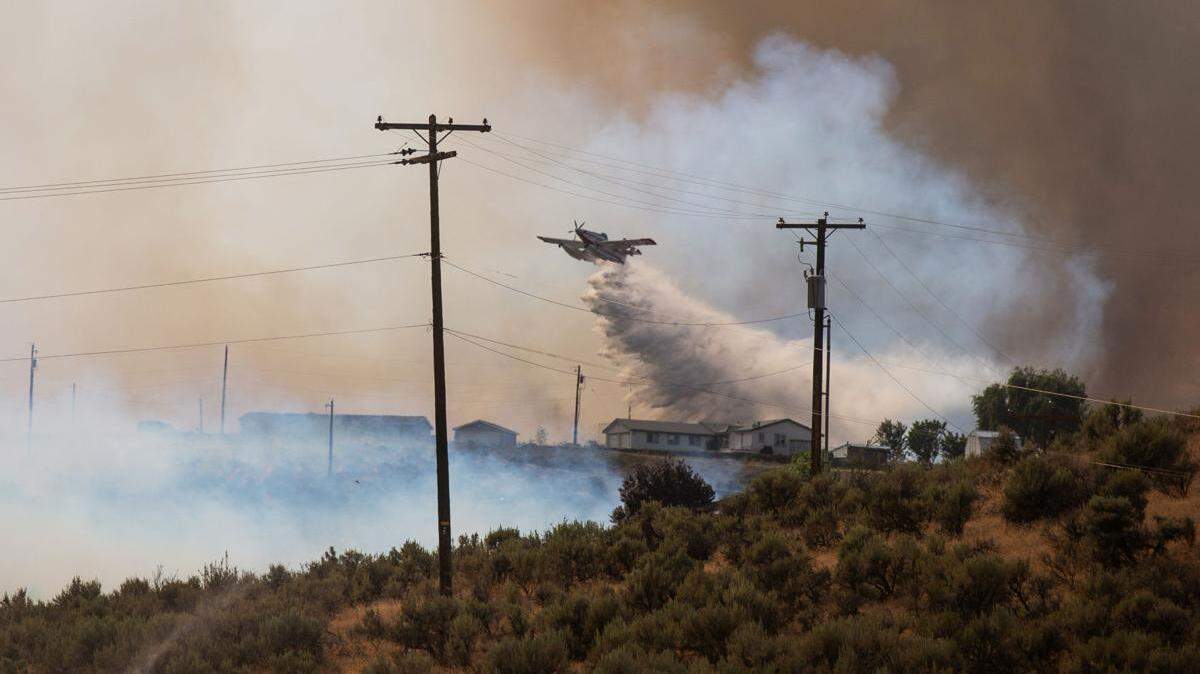 Firefighters from several area agencies respond to a brush fire that started near Conrad Road in Selah, Washington, on Sunday afternoon. Dozens of homes were threatened as steady wind pushed the blaze to grow to thousands of acres.