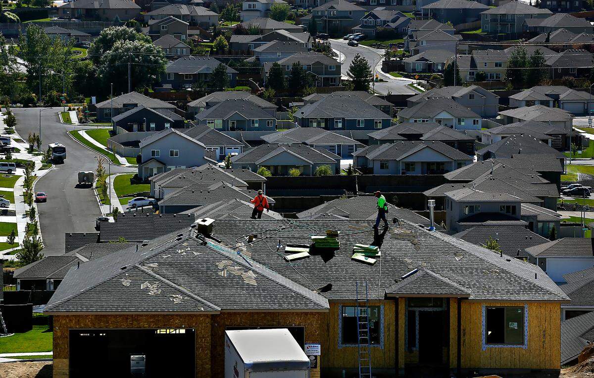 Workers put shingles on the roof of a new home under construction on the 6000 block of West 30th Avenue in the Southridge area of Kennewick.
