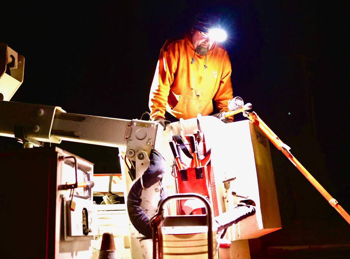 A Benton REA lineman works in the wind early morning Wednesday, preparing to disconnect power to repair a downed power line near North 62nd Avenue in West Richland.