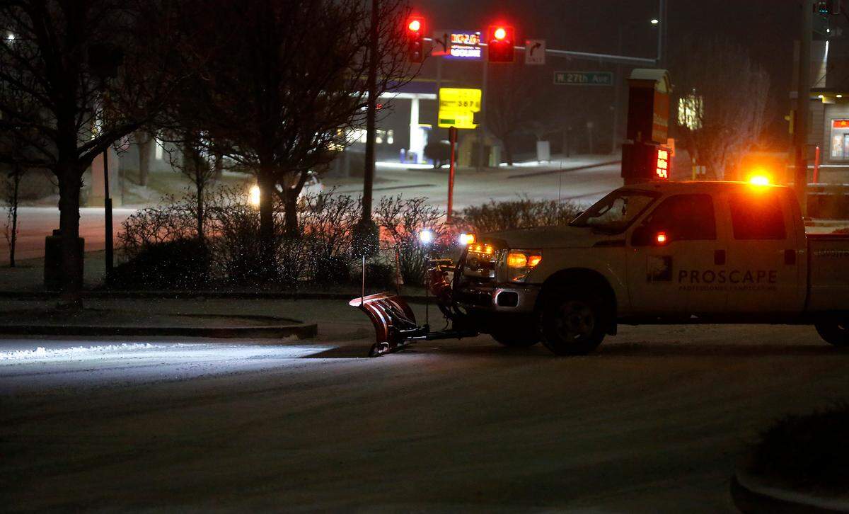 A commercial plow clears snow from a retail business parking lot early Thursday morning off West 27th Avenue near South Quillan Street in Kennewick. An overnight snowfall coated the Mid-Columbia causing several school delays in outlying areas.