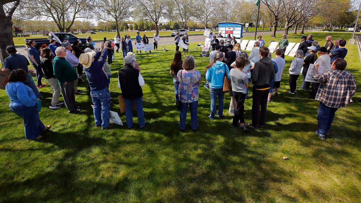 About 75 to 100 gather outside the Richland office of Rep. Dan Newhouse during Wednesday’s rally organized by Indivisible Tri-Cities.