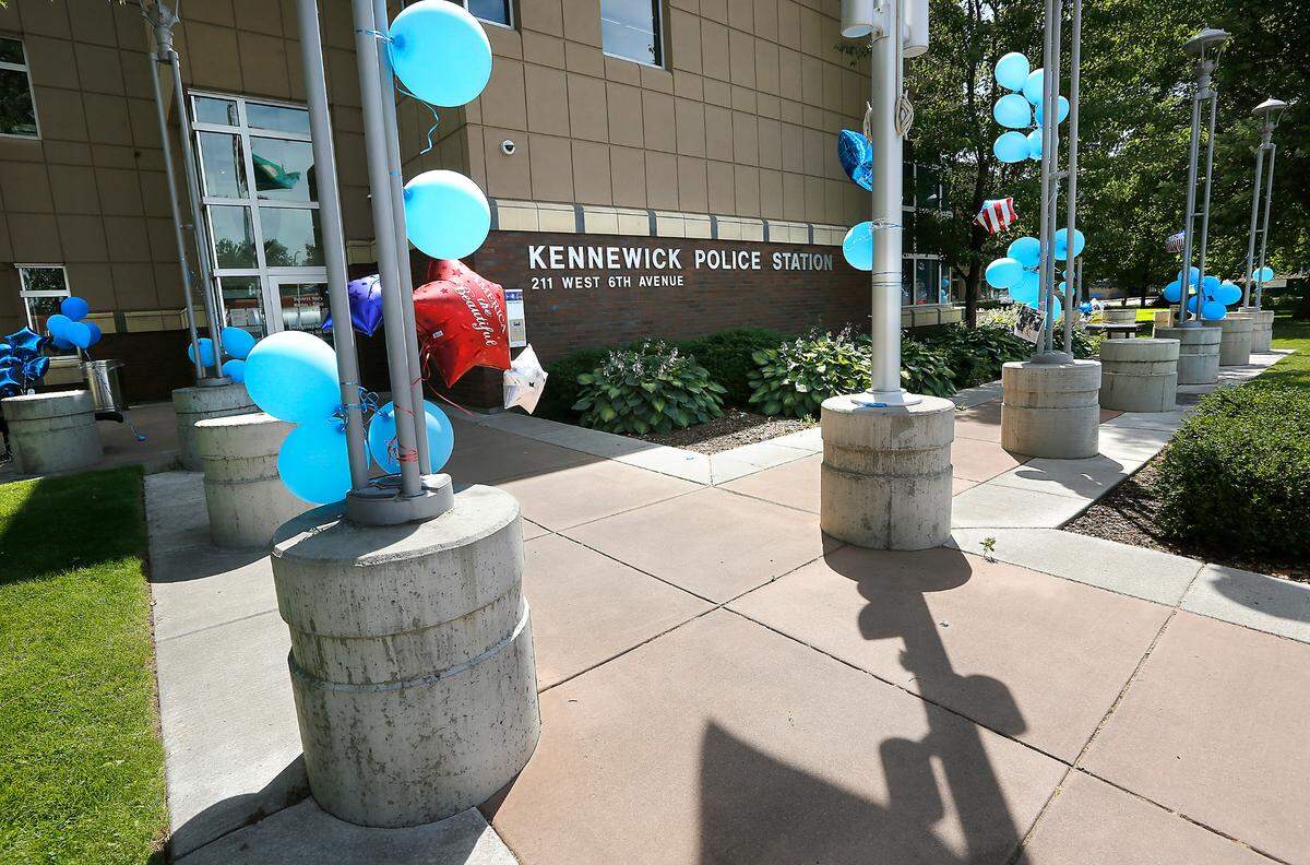 Dozens of blue balloon, pictures, notes and other colorful balloons have been left outside the Kennewick Police Department Friday after it was announced a planned Back The Blue rally of support was canceled by what organizers described as credible threats.