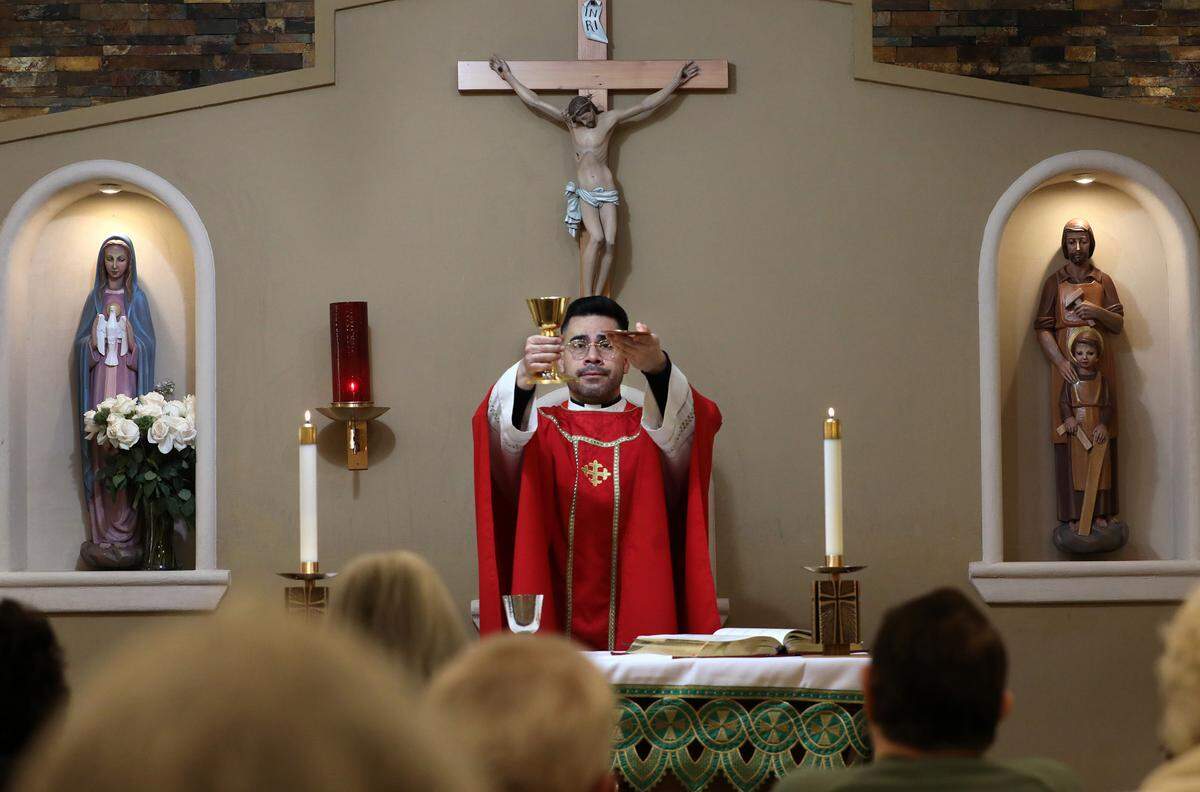 Rev. Cesar Izquierdo presents the Eucharist to parishioners during a recent morning mass held in the chapel of the St. Rose of Lima Catholic Church in Ephrata.
