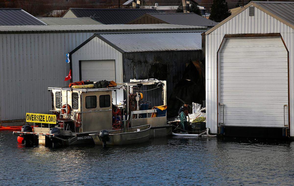 Crew members from a Spokane diving salvage business work Wednesday at the site of the early December boathouse fire that destroyed and sank two boats at the Clover Island Yacht Club in Kennewick.