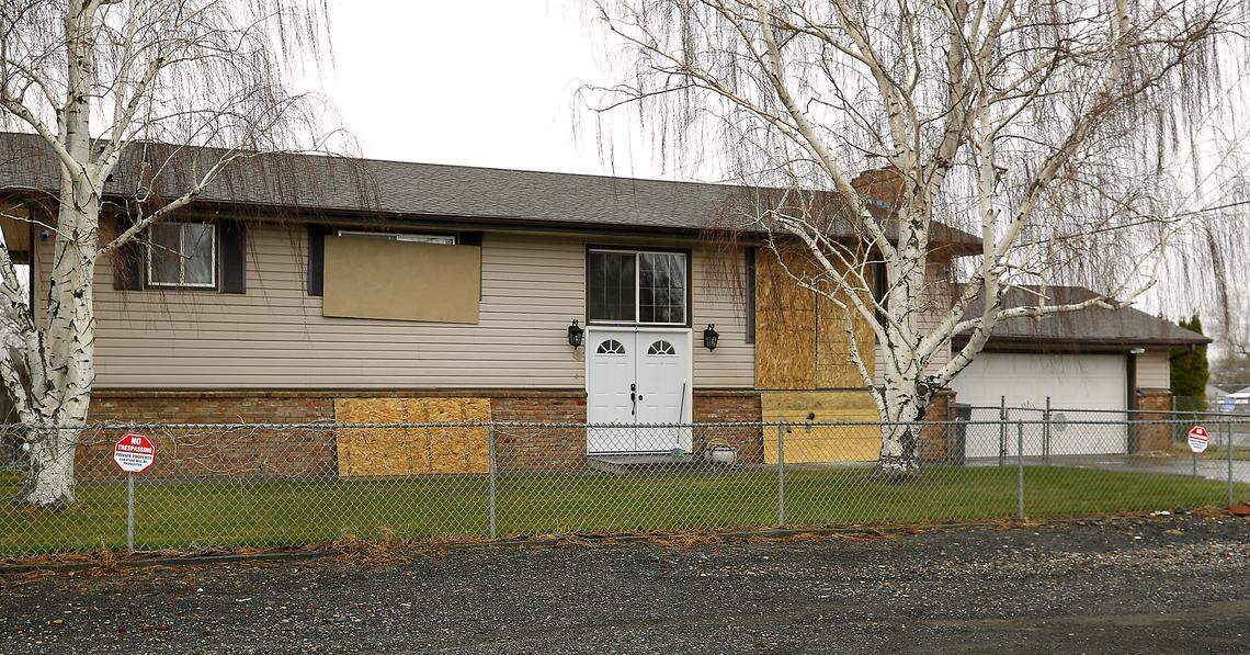 After recent vandalism, sheets of plywood cover broken windows of the split-level home at the corner of Edison and Eighth Avenue.