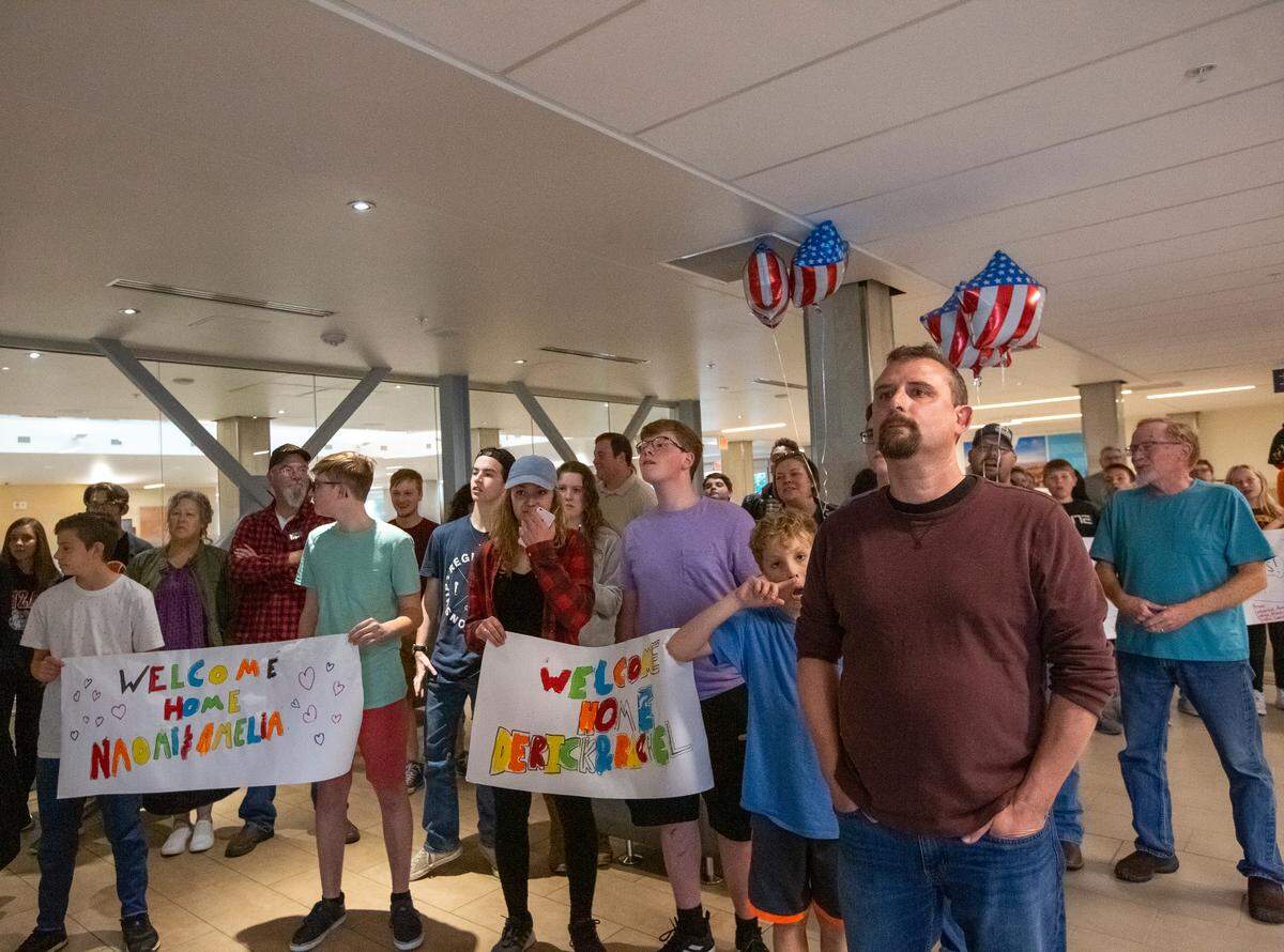 Ralph Perko, right, waits with friends and families for his new adopted daughters and other children to arrive from an orphanage in Sierra Leon.