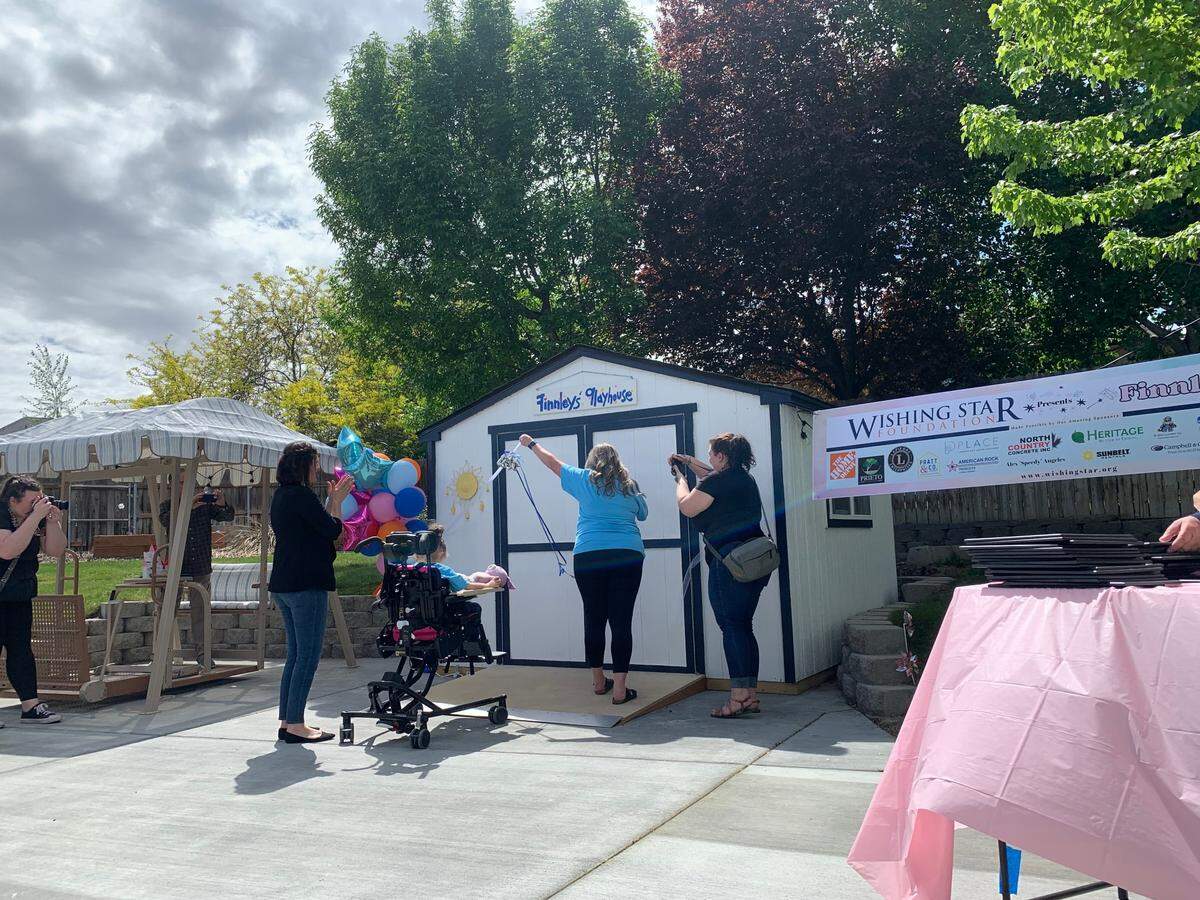 Codi and Finnley Couchman cut the ribbon on Finnley’s Playhouse at an unveiling event.