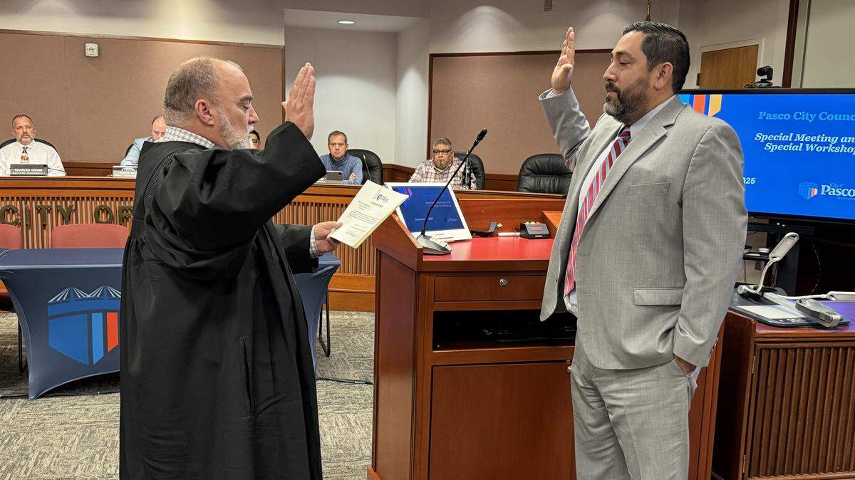 Pasco Municipal Court Judge Craig Stilwill swears in Carlos Villarreal as the new municipal court judge on Dec. 8, 2025, in front of the Pasco City Council.