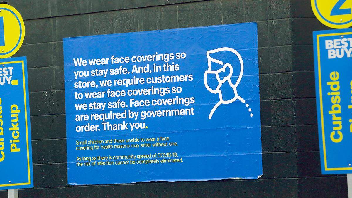 A banner on the side of the Best Buy store in Kennewick near the curbside pickup area reminds customers of the requirement of wearing facing coverings during the coronavirus pandemic.