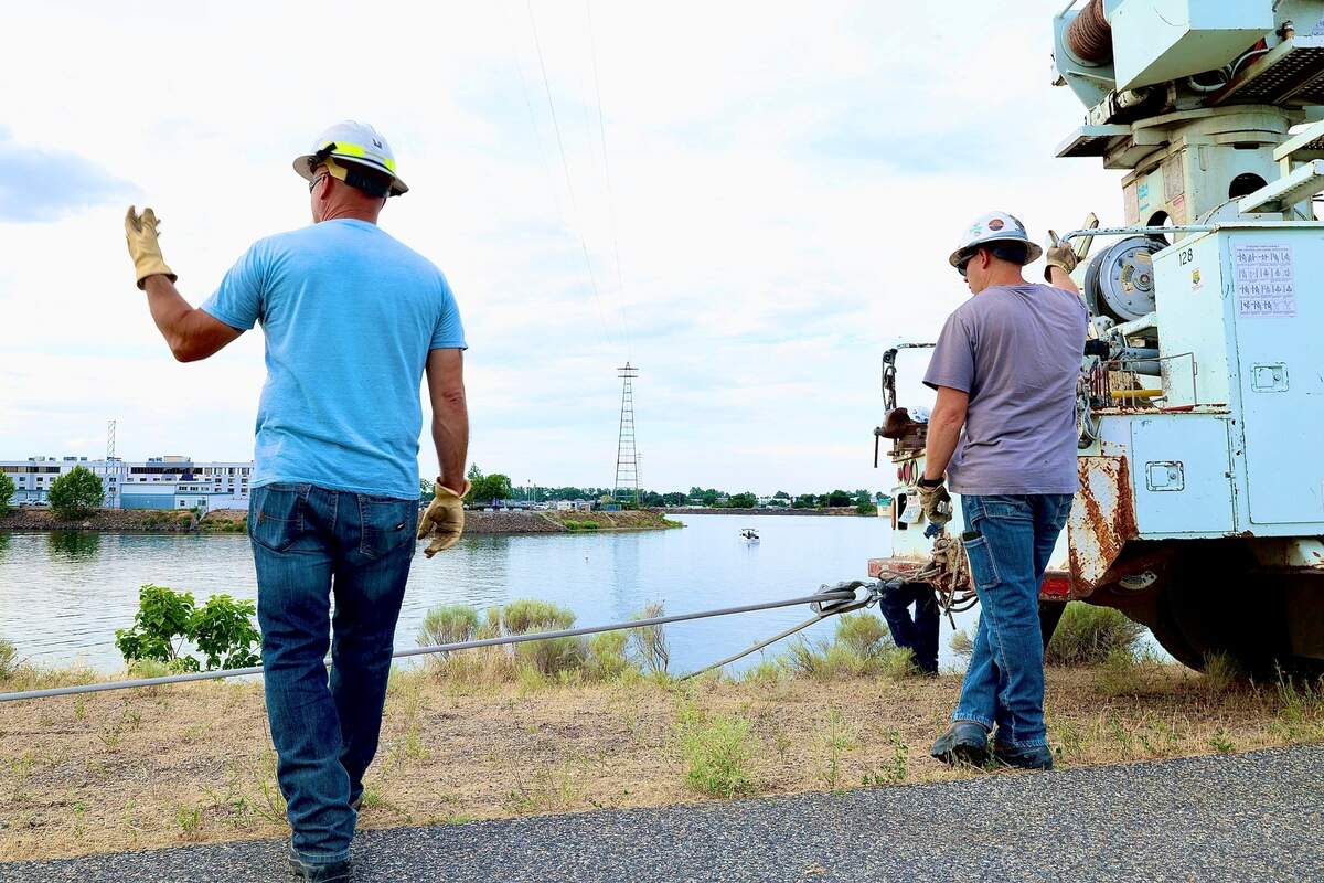 Benton PUD crews work to repair a damaged power line near Clover Island in Kennewick after a floatplane broke the wire and crashed into the Columbia River killing two men onboard.