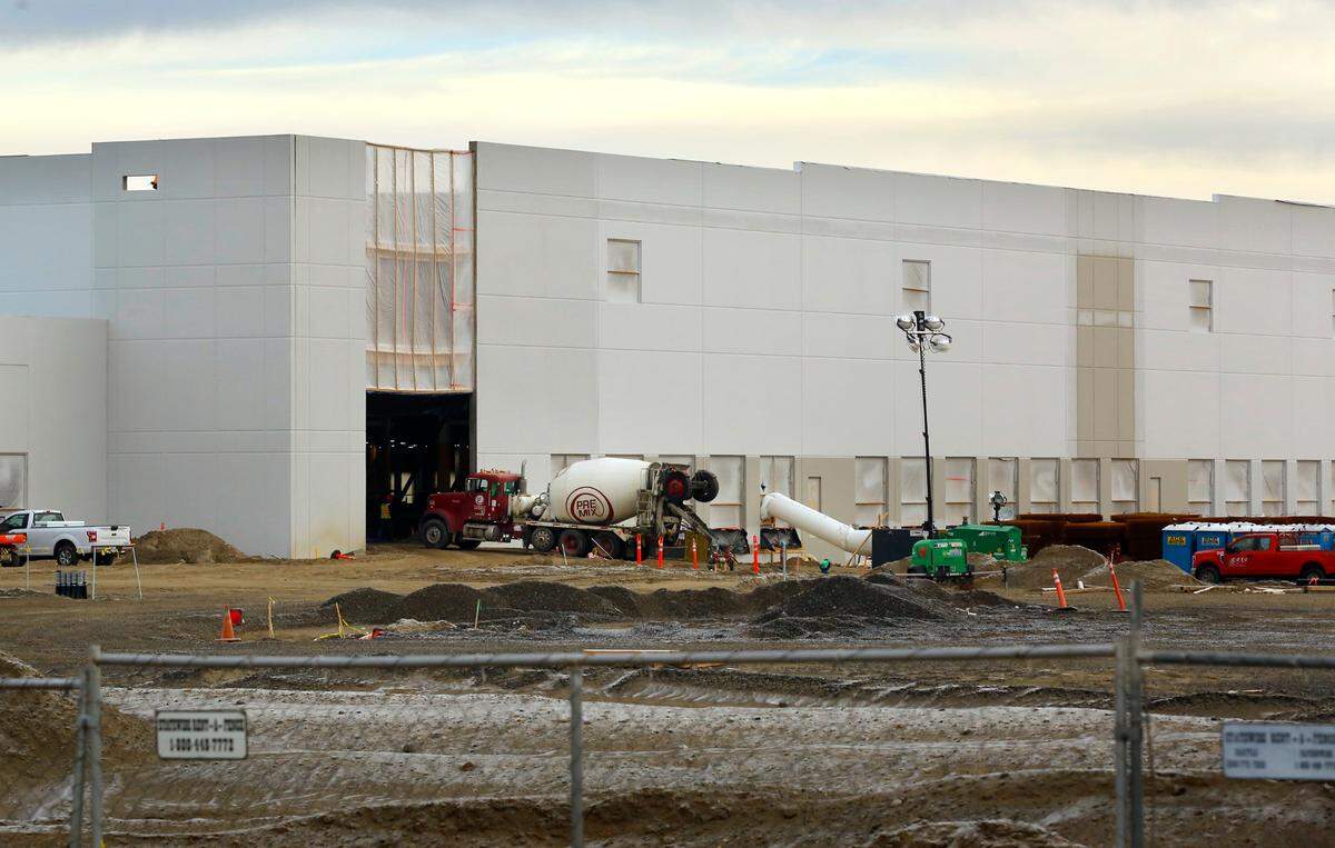 A truck delivers a load of concrete to inside one of two large Amazon warehouse buildings under construction on South Road 40 East in Pasco.