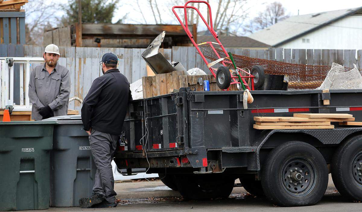 Nick Mutrux, Richland code enforcement supervisor, talks with homeowner Taylor Knipp Tuesday morning after the city of Richland started clearing unlicensed vehicles and other items blocking the sidewalk and public right-of-way.