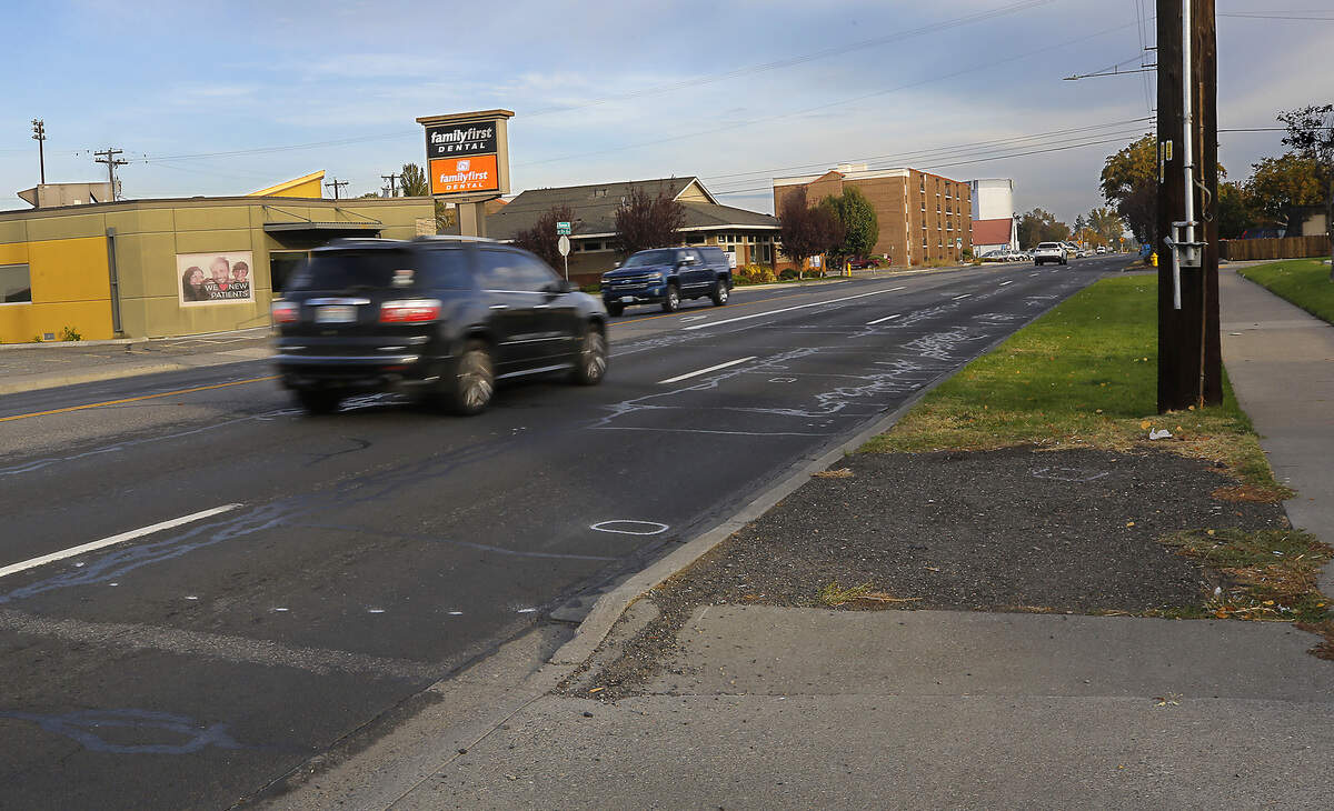 Traffic moves past the investigative paint markings where, Magdalena Castillo, 75, was hit and killed Wednesday evening as she walked across Washington Street.