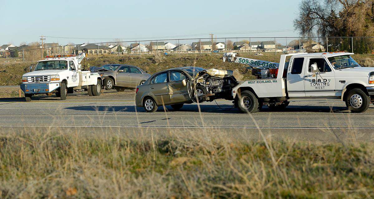 Tow trucks haul damaged cars involved in Monday’s fatal multiple-vehicle crash on Interstate 182 in Pasco west of Road 100. The wreck caused traffic to backup in both the eastbound and westbound lanes into Richland on the twin bridges over the Columbia River.