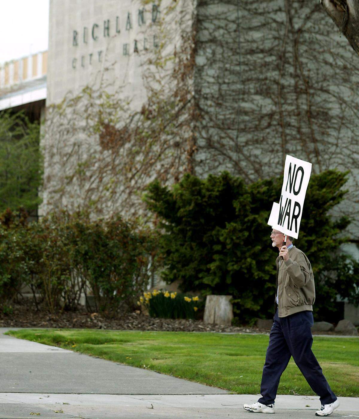Jim Stoffels of Richland protests war along the sidewalk in front of Richland City Hall on George Washington Way in 2003.