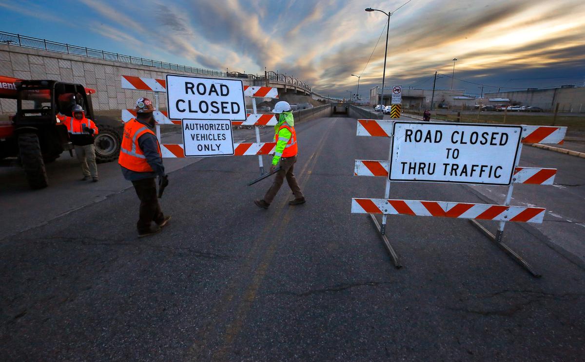 Construction workers block off the west end roadway of the Lewis Street underpass early Monday as the first step in preparing to demolish the historic underground structure.