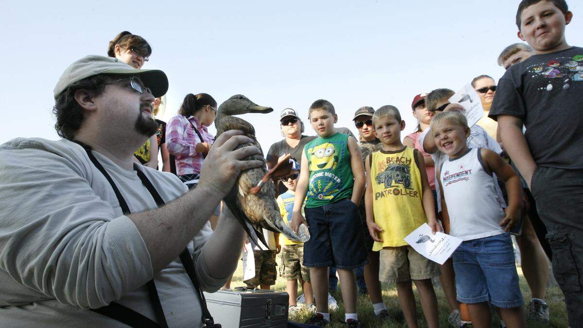 A volunteer shows a duck he just banded to children and adults during Kids Duck Conservation Day at McNary National Wildlife Refuge in Burbank.