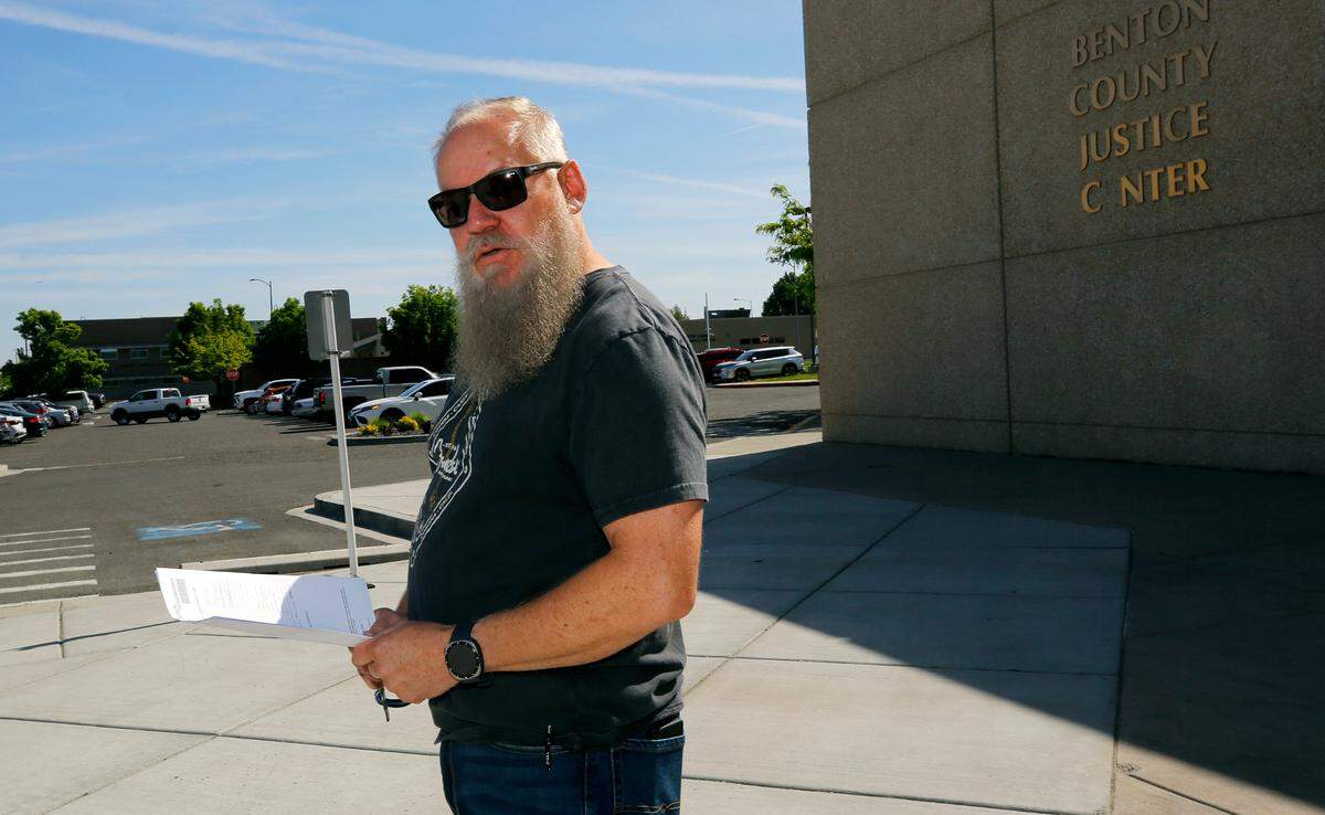 Mark Almquist of Pronto Process Service announces the postponement of the public auction for the Farmers Exchange properties in downtown Kennewick Friday morning at the Benton County Justice Center in Kennewick.