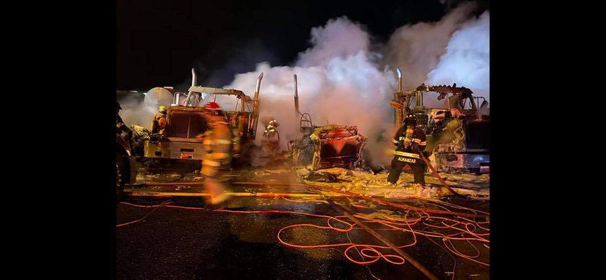 Fire crews battle a fire that destroyed seven trucks at Harms Pacific Transport.