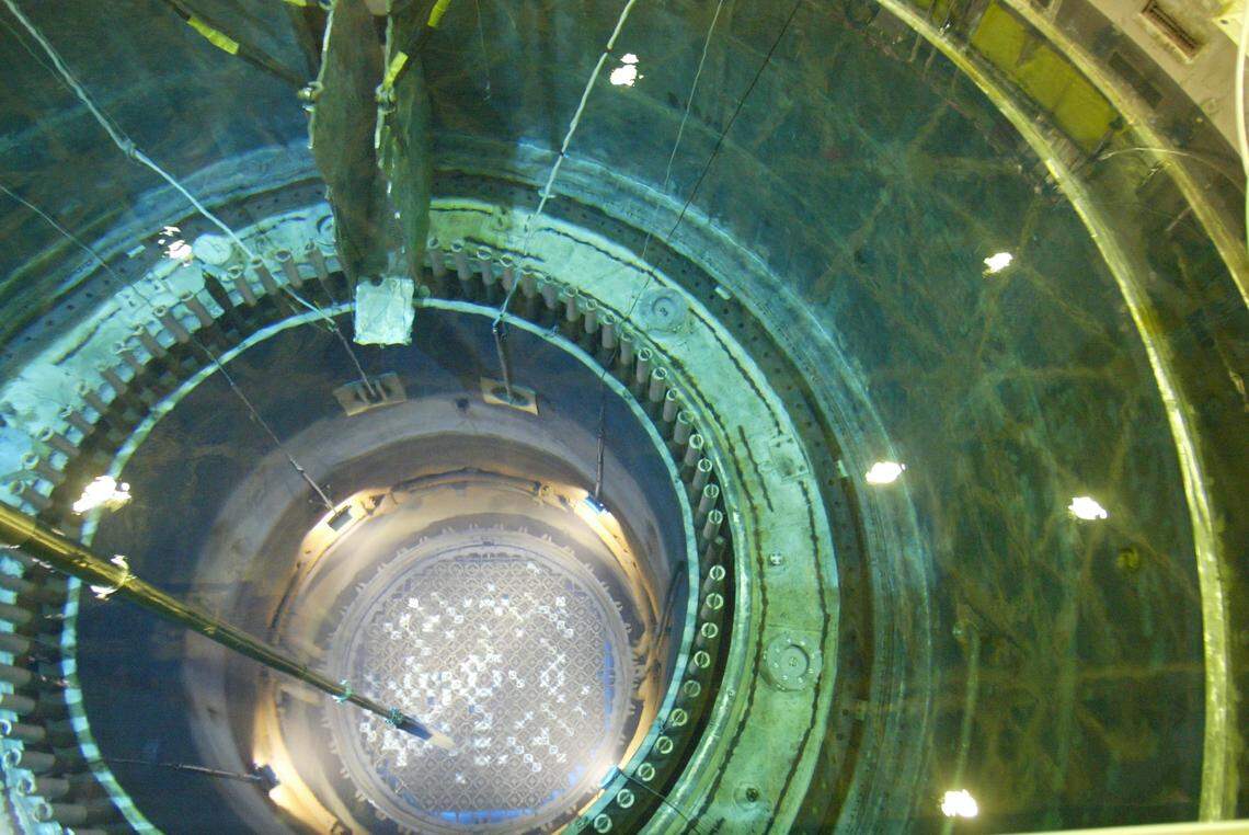 A long robotic arm reaches down through 70 feet of water to move a spent nuclear fuel bundle inside the open core of Energy Northwests reactor north of Richland during a previous refueling outage.