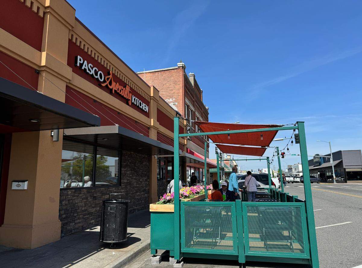 Customers sit inside the outdoor seating area in front of the Pasco Specialty Kitchen in downtown Pasco.