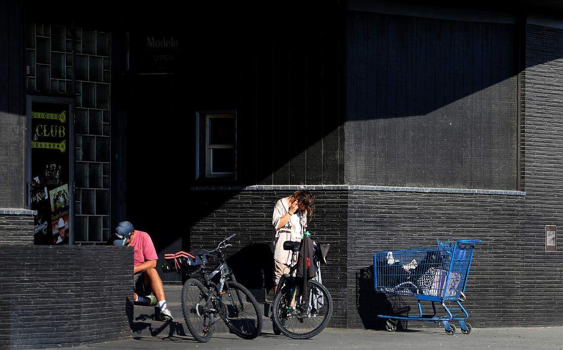 Several people gather with their belongings in the entryway of a night club across the street from the Tri-City Union Gospel Mission in downtown Pasco.