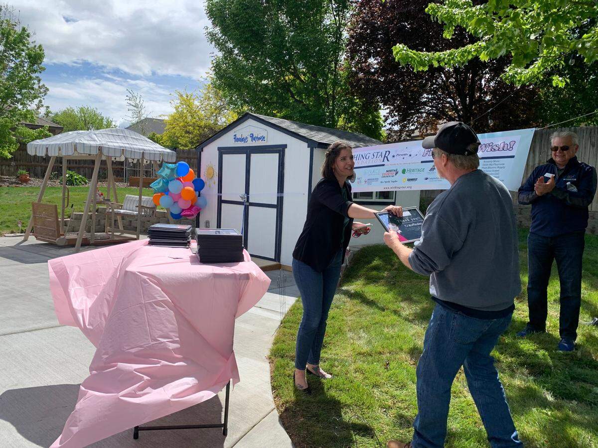 The Wishing Star Foundation’s Wish Programs and Outreach Manager Ashleigh Rogers offers a certificate of gratitude to TJ Woffinden for his part in the wish granting.
