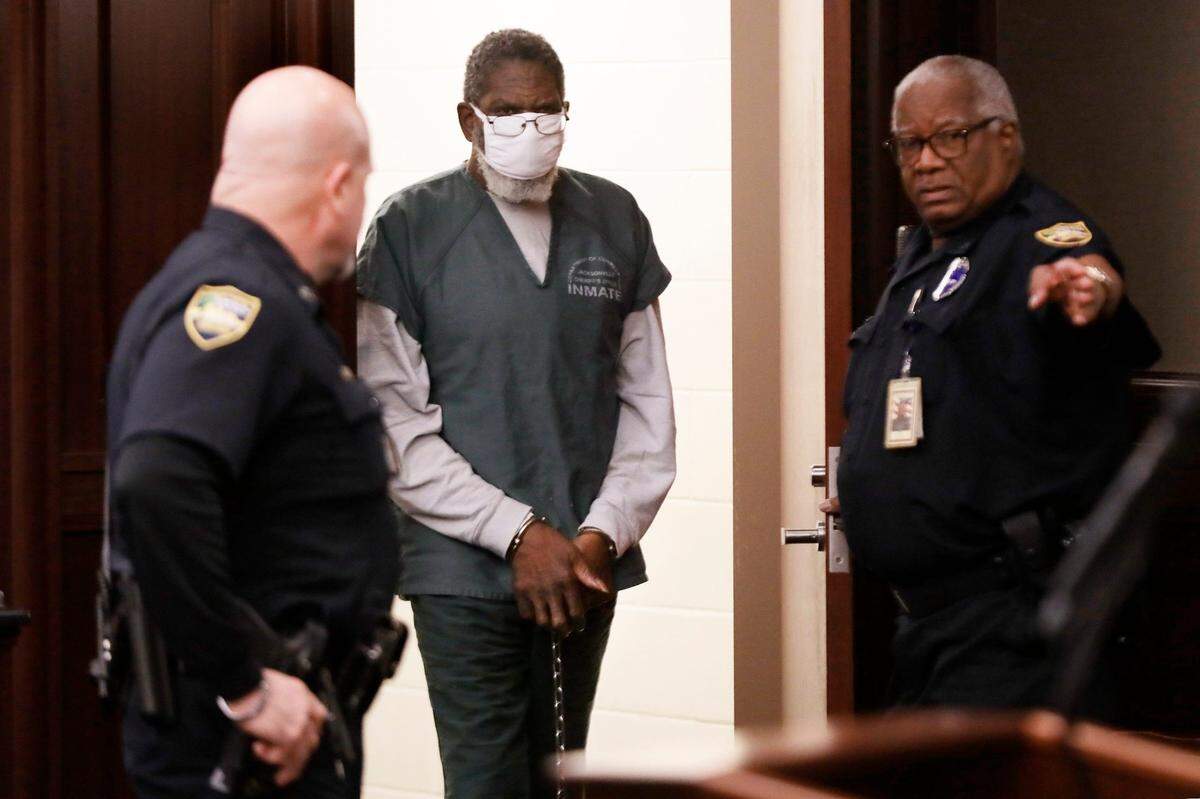Henry Tenon is directed into the courtroom by bailiffs for his first hearing on charges of conspiracy to commit murder, second-degree murder with a weapon, accessory to the fact to a capital felony, and child abuse in the Jacksonville Beach shooting death of Jared Bridegan on February 16, 2022. The hearing was held Monday morning, February 13, 2023 in a courtroom of the Duval County Courthouse in Jacksonville, Florida with Bridegan’s widow, Kirsten Bridegan, along with family and supporters in the gallery for the brief appearance. Jki 021323 Tenon Arraignment 01
