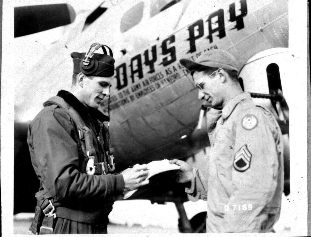 Day’s Pay pilot Arlys “Duane” Wineinger, left, talks with ground crew chief Salvadore Leto at the B-17 bomber he flew.