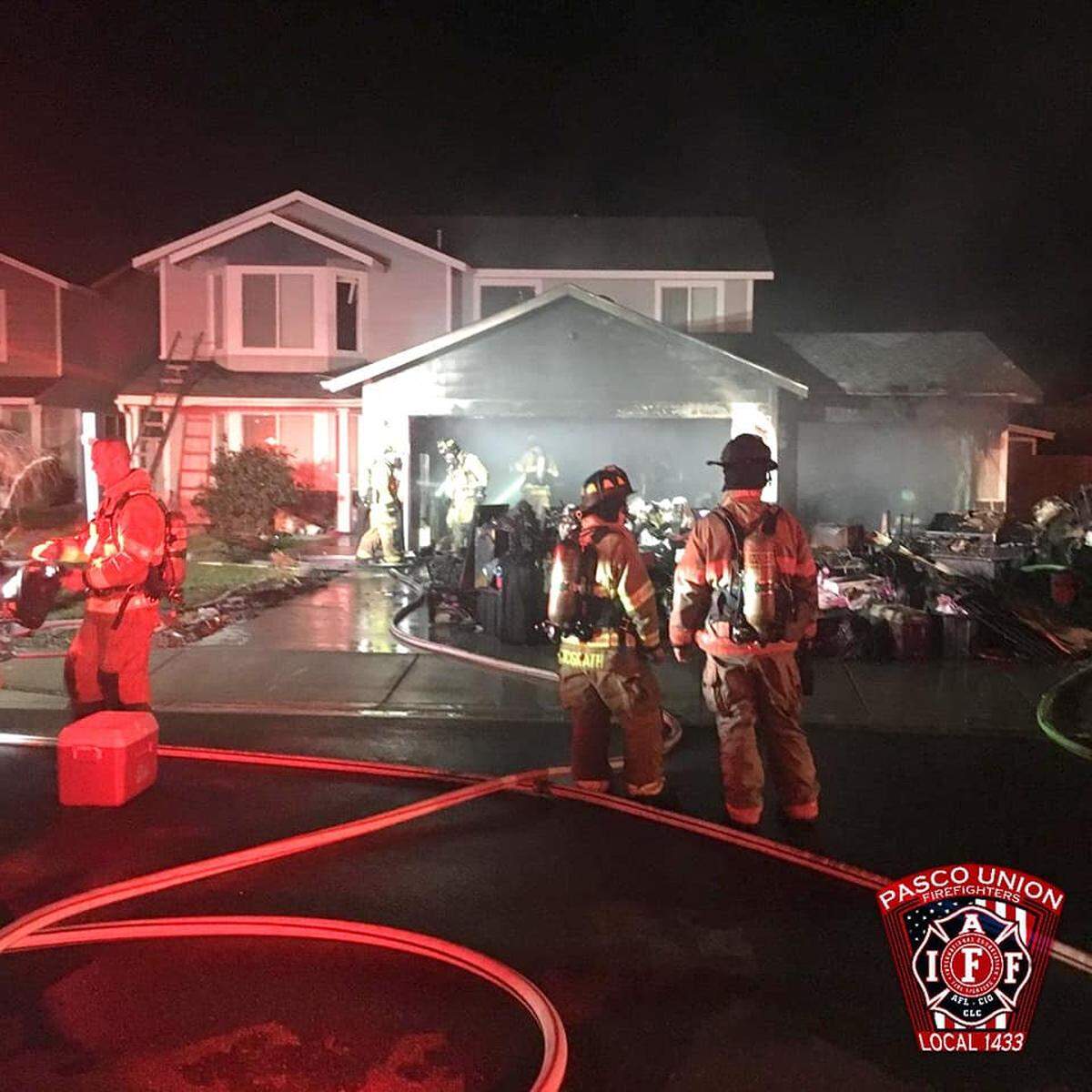 Firefighters pulled belongings out of a garage Thursday night after a Pasco home caught fire.