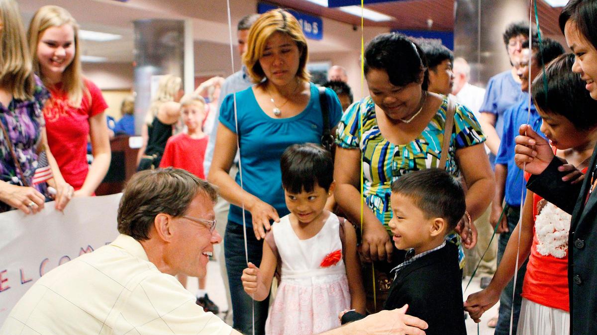 Peter Bengtson, a World Relief volunteer, meets Ling Phe, 7, in July, 2012 after he and his siblings Sum Phe, 9, center, Lei Phe, 14, right, and Awi Phe, 11, reunited with their parents Aum Phe, not pictured, and Shuepai Phi, seen with her head bowed, after three years. The family became separated while escaping persecution from Myanmar. Bengtson helped them adjust to life in Kennewick as they worked to get their children to the United States.