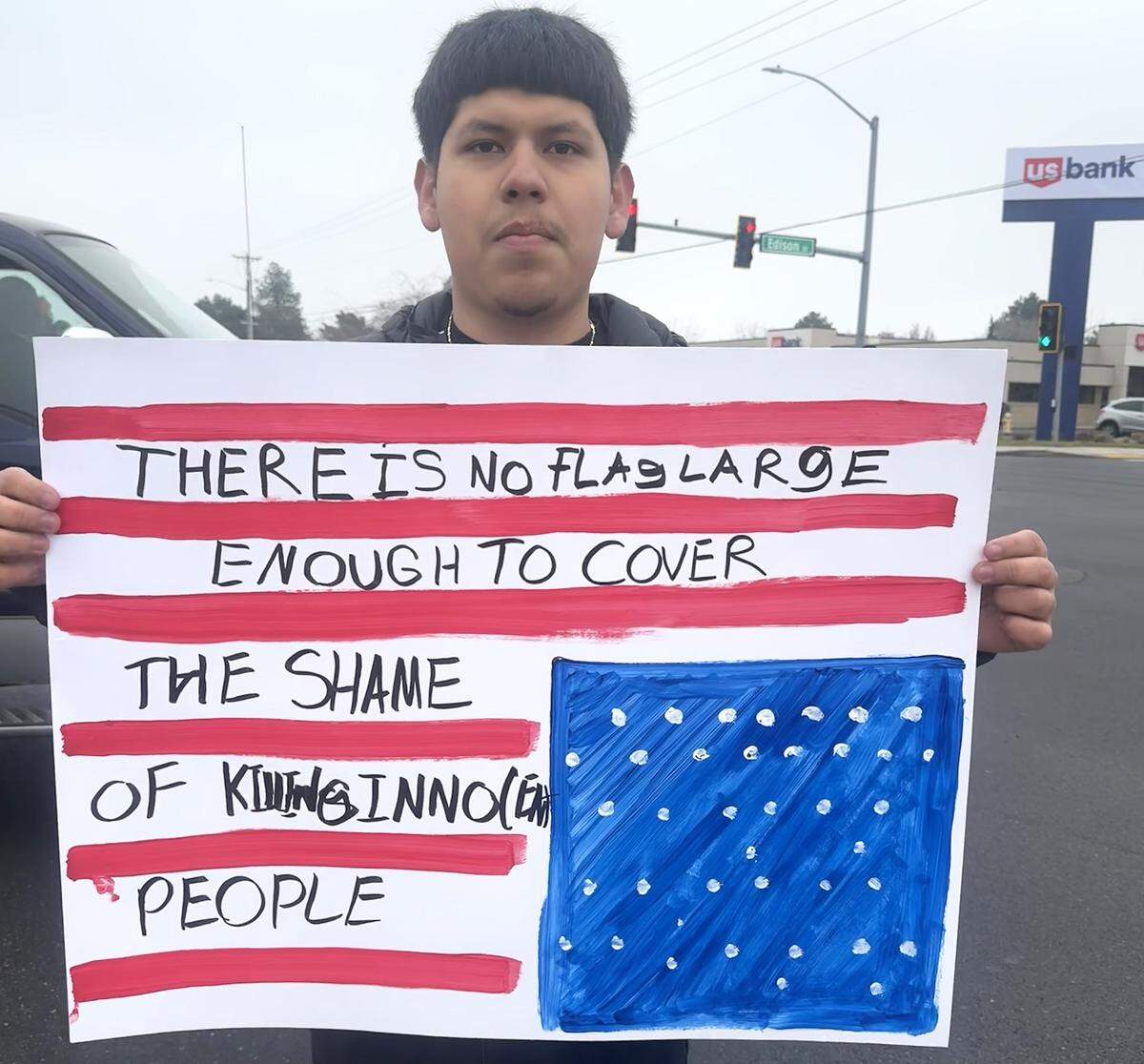 Diego Martinez, a senior at Kamiakin High School, holds a sign during Friday's walkout and march in Kennewick.