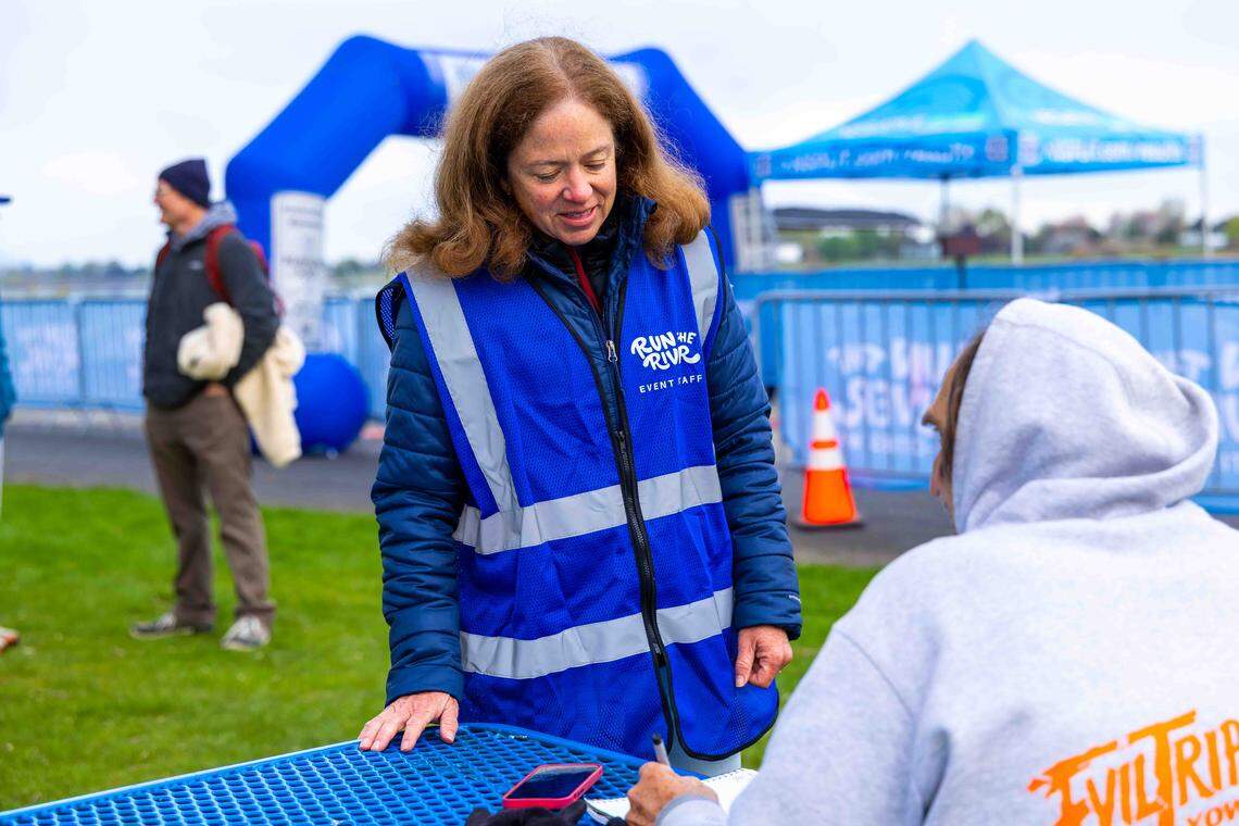 Christie Hayes of West Richland, a Run the River organizer and marathon runner, speaks with a participant before the race Saturday, April 18, 2026, at Columbia Park in Kennewick. Hayes has completed 115 marathons.
