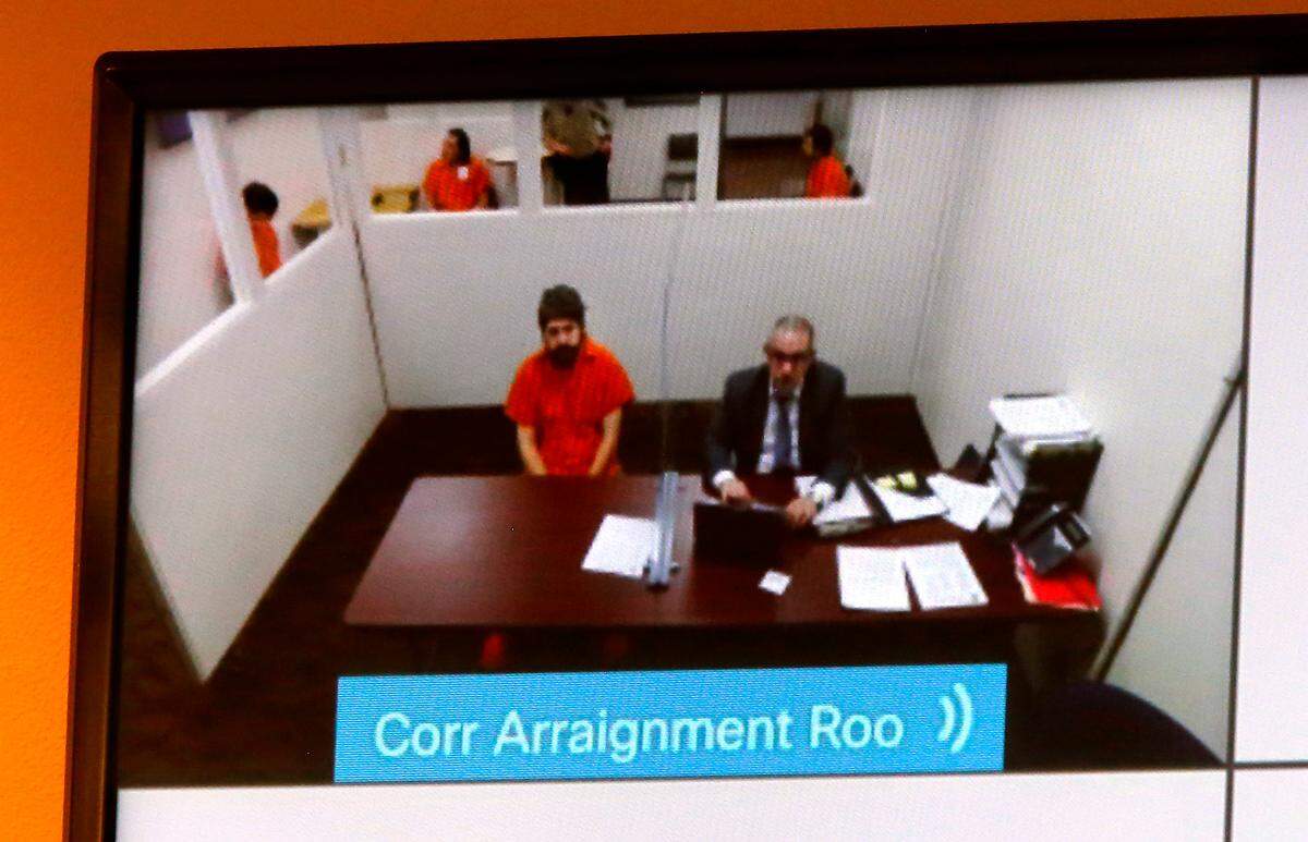 Murder supect Joshua Dian Davis, left, appears in this file photo for another hearing in Franklin County Superior Court with one of his attorneys, Peyman Younesi, via a video link Tuesday in Pasco.