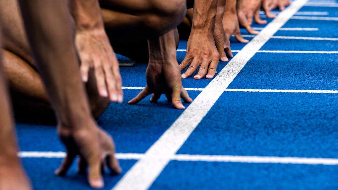 Track sprinters line up at the start for a race.