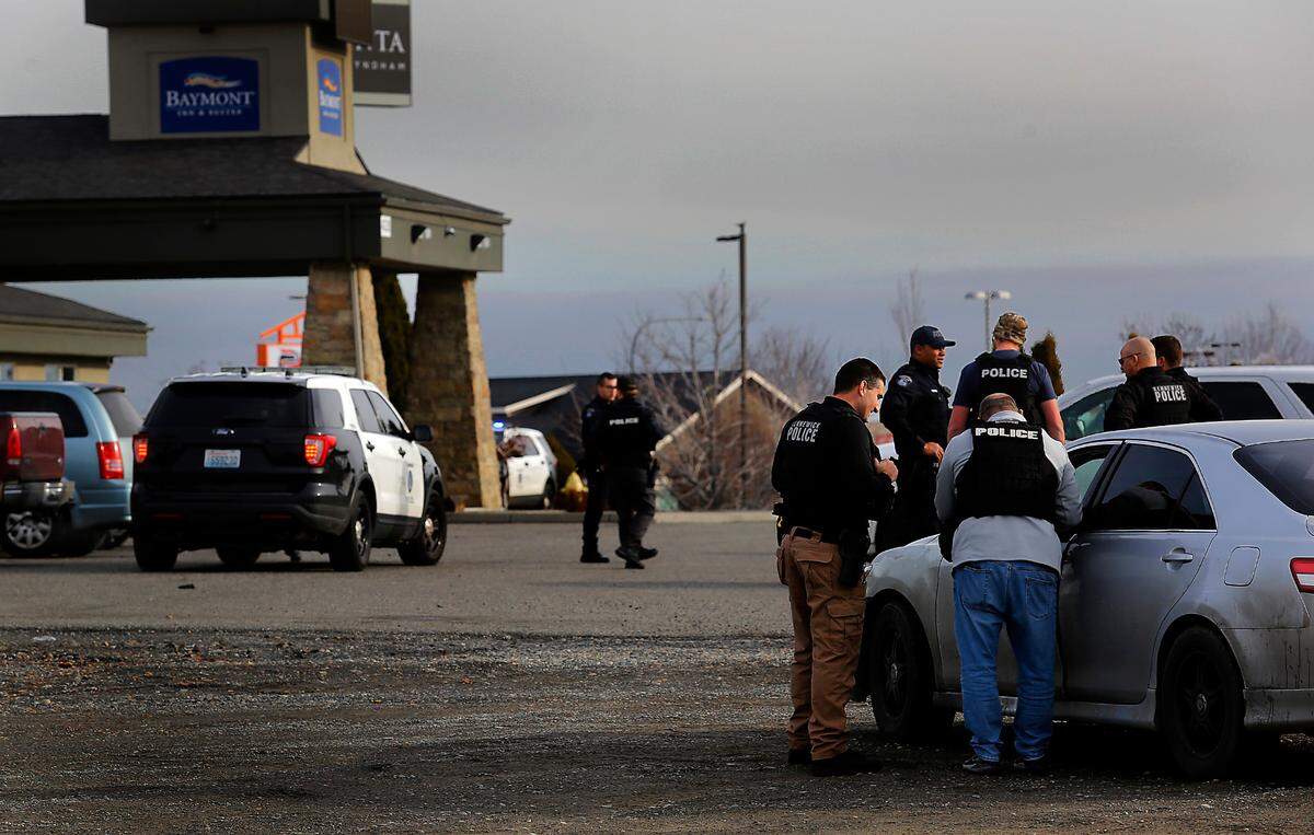 Kennewick police officers surround the Baymont Inn & Suites on West 27th Place in Kennewick in connection with a series of residential burglaries in the Tri-Cities region.