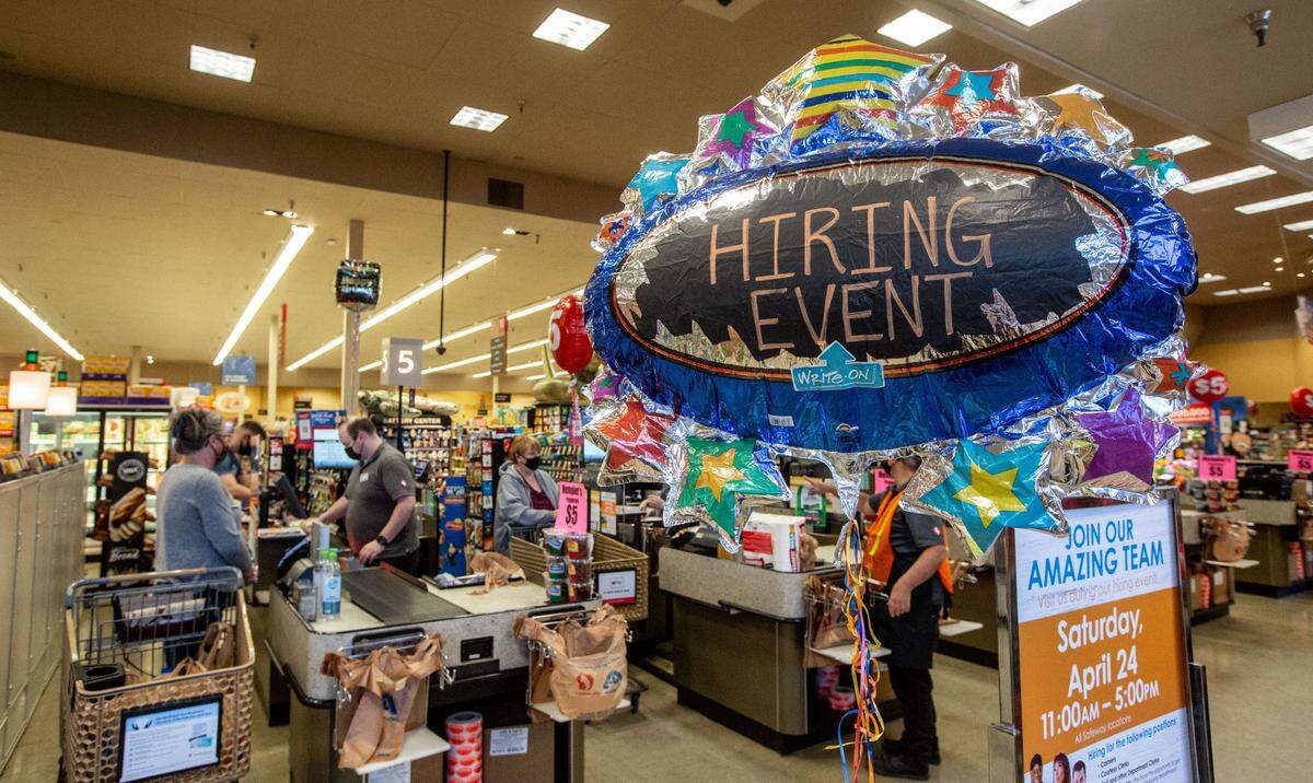 A balloon advertising a hiring event floats near the checkout lanes at Safeway on George Washington Way in Richland. Grocery stores have seen a surge in demand for workers leading to job fairs like the one in central Washington Safeway and Albertsons.